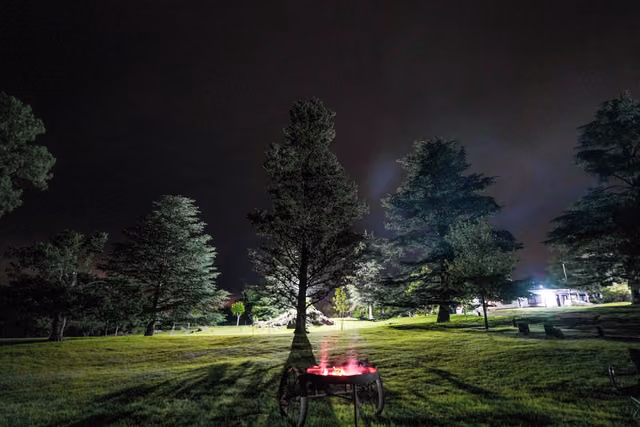 Un fogón encendido en el parque, de noche
