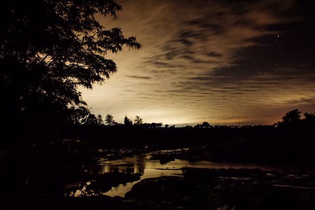 El río al anochecer, con nubes iluminadas